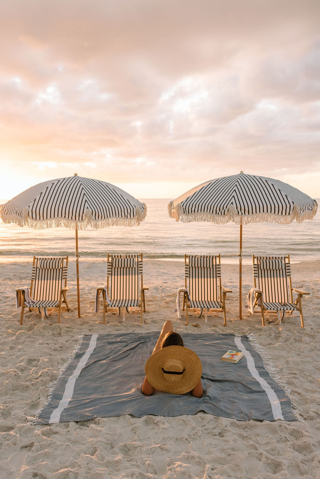 Chilled glasses and styled details on a beach table at sunset in Naples